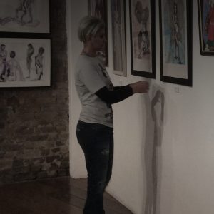 Barri's picture in menier gallery, she is standing in front of her two angles paintings